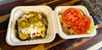 two plastic containers with burgers in them